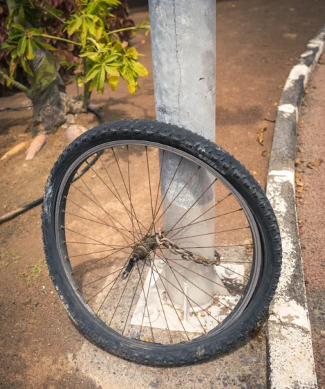Old Bike Wheel Chained to a Pole