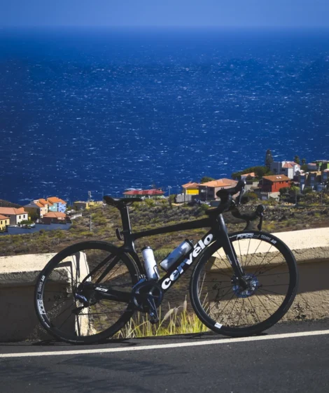 Road Bike Parked on a Wall Overlooking a Town and the Ocean