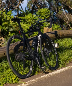 Black Road Bike Parked on a Wooden Railing