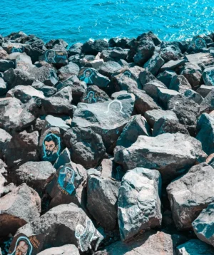 Person's Face on Pile of Rocks by the Water