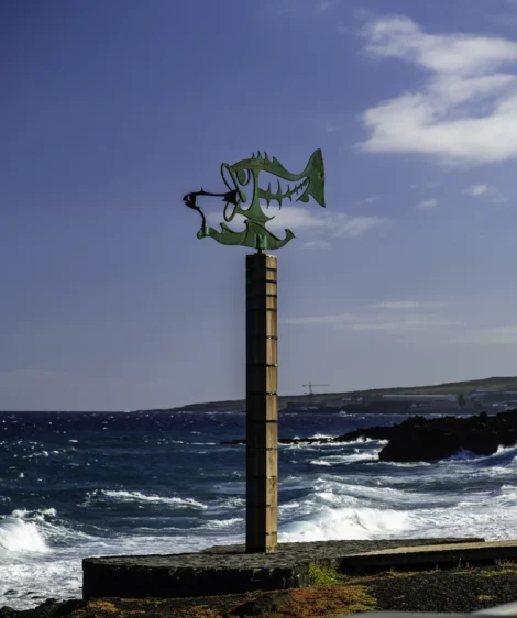 Wooden Post With Dragon on It by the Ocean