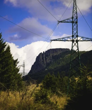 Tall Metal Tower With Trees and Mountains in the Background