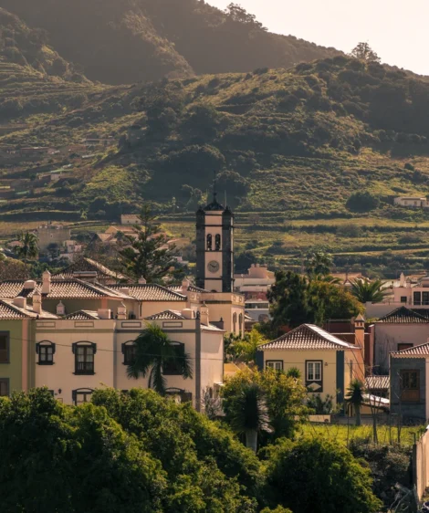Group of Buildings With Trees in Front of Them and Mountains in the Background