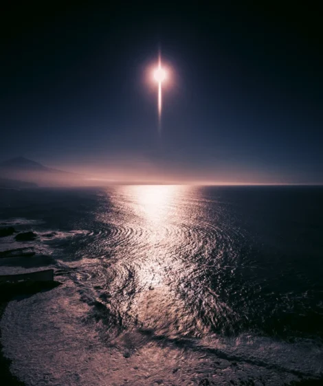 Rocket Launching Over Body of Water at Night