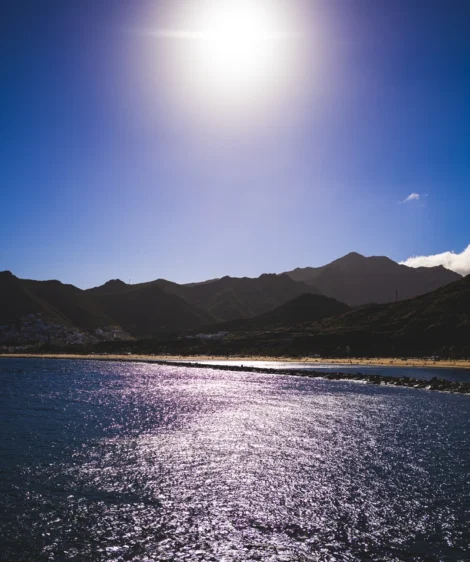 Body of Water With Mountains in the Background