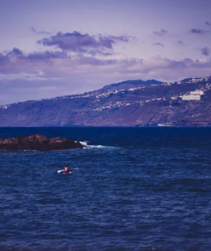 Couple People on Boat in the Water With Mountains in the Background