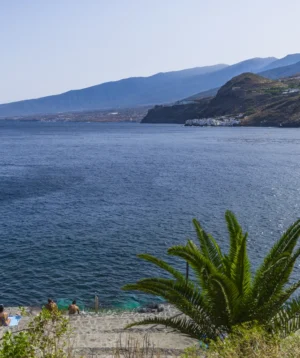 Body of Water With People on It and Mountains in the Background