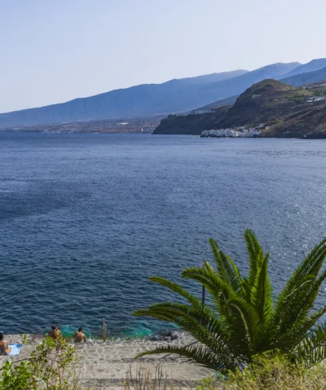 Body of Water With People on It and Mountains in the Background