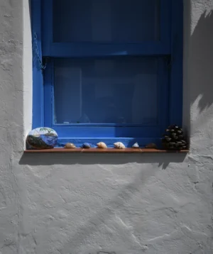 Window With Blue and White Curtain and Group of Objects in It