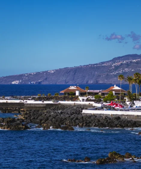 Body of Water With Rocky Shore and Building on the Other Side