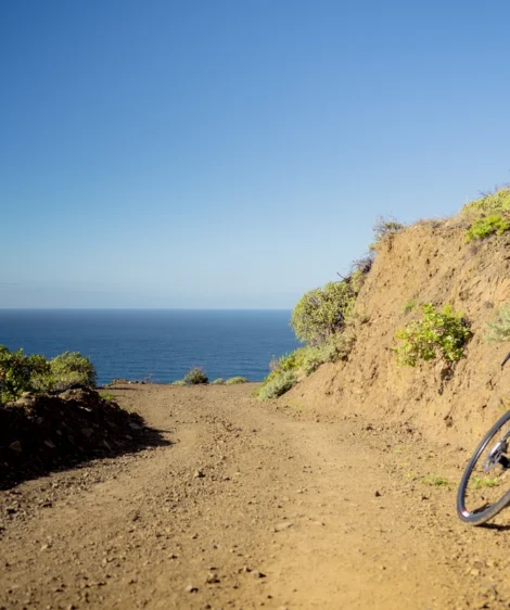 Bicycle Parked on Dirt Path by Body of Water