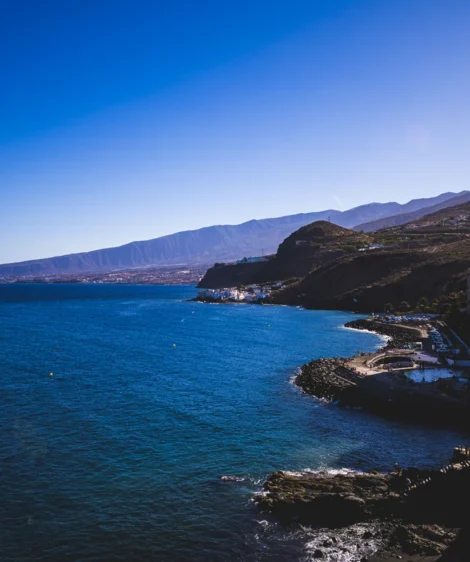 Body of Water With Buildings and Mountains in the Background