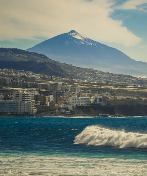 City Next to Body of Water With Mountain in the Background