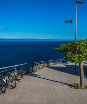 Sidewalk With Bicycles and Body of Water in the Background
