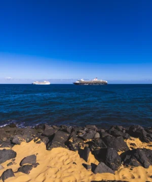 Rocky Beach With Couple of Ships in the Distance