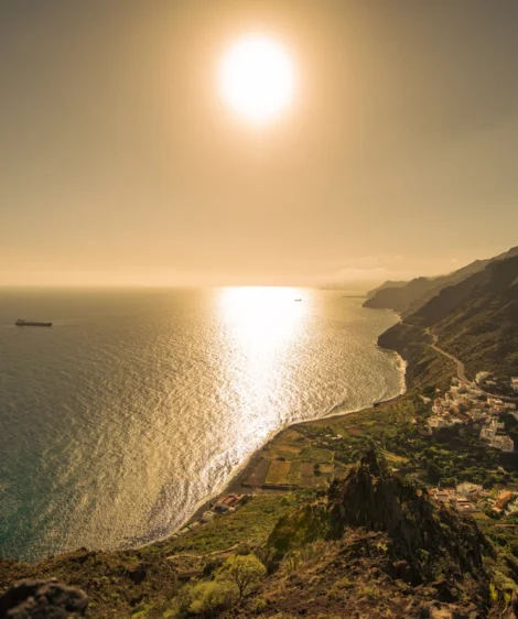 Body of Water With Boat in It and Hill With Building on It