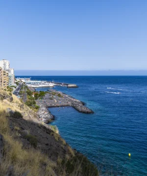 Body of Water With Rocky Shoreline and Buildings on the Side
