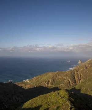 Body of Water With Hills and Land With Boat in It