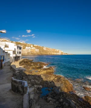 Path Next to Body of Water With Buildings Along It