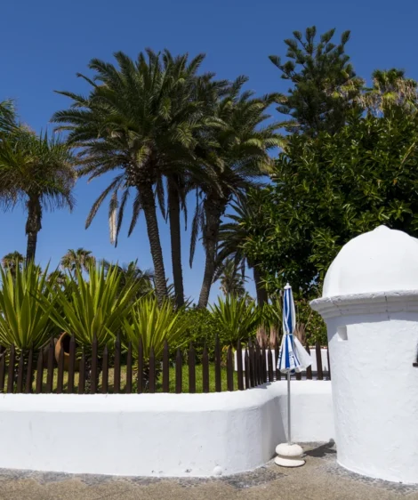 White Statue in Front of Fence and Trees
