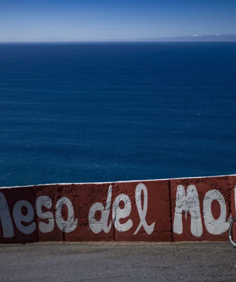 Bicycle Parked on Wall Next to Body of Water