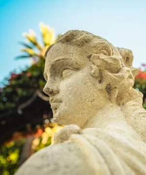 Statue of Person With Flowers in the Background