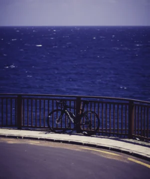 Bicycle is Parked on Railing Overlooking Body of Water